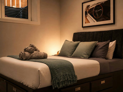 Stylish guest bedroom with premium bedding and automotive artwork