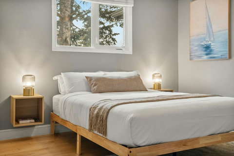 Serene guest bedroom flooded with natural light and tree views