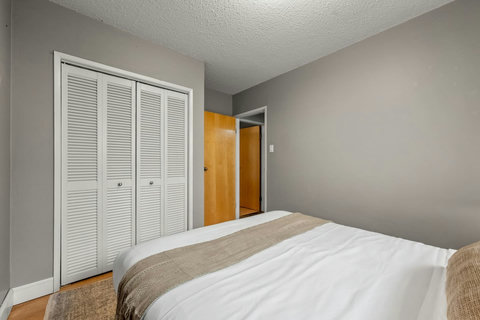 Cozy guest bedroom with ample closet space and warm hardwood floors