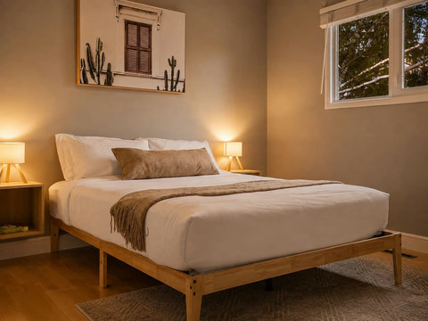 Cozy guest bedroom with warm lighting and modern wooden frame bed
