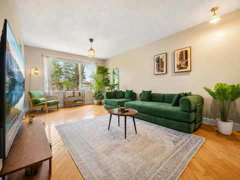 Bright living room with comfortable seating and lush greenery throughout