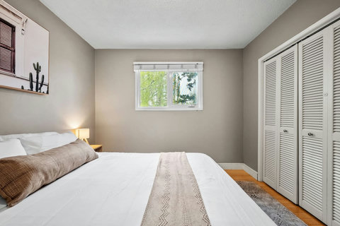 Comfortable guest bedroom flooded with natural light and modern storage.