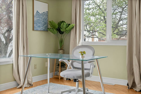 Sunny workspace featuring a glass desk and modern furnishings throughout