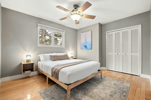 Light-filled guest bedroom with natural wood furnishings and ample storage