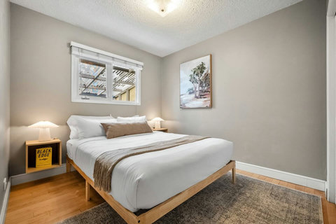 Inviting guest bedroom with warm wood furnishings and plenty of natural light