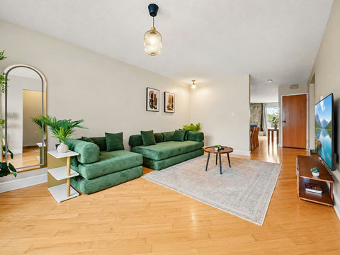 Comfortable living space with a stylish green sectional and warm wood flooring