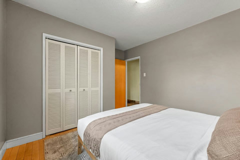 Cozy guest bedroom featuring ample storage and warm wood flooring