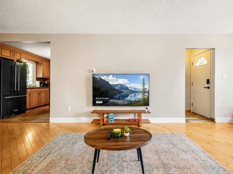 Spacious living room with smart TV and stylish wooden furniture