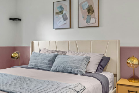 Stylish bedroom retreat with designer headboard and curated artwork above