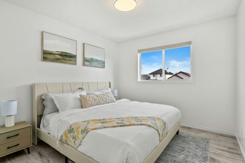 Serene guest bedroom with soft natural light and charming neighborhood views