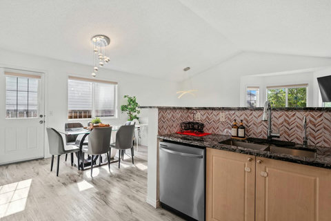 Sleek kitchen featuring black granite counters and stylish herringbone tile backsplash