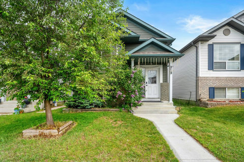 Charming front entrance framed by lush mature trees and flowering shrubs