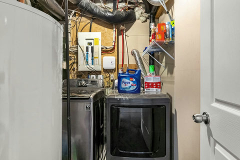 In-unit laundry room with washer, dryer, and convenient storage