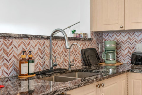 Stylish kitchen featuring granite counters and striking herringbone tile work