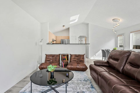 Bright, modern living space with comfortable leather seating and open kitchen.