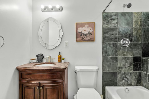 Spa-inspired bathroom with vintage wood vanity and luxurious tiled shower.