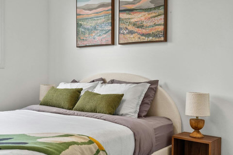 Cozy guest bedroom with soft upholstered headboard and nature artwork