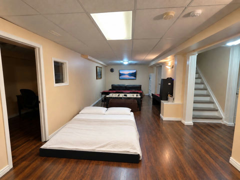 Optional basement sleeping setup: a 6-inch queen folding floor mattress, shown on the entertainment-room floor. Mattress and linens are stored in the gym closet; move games furniture aside and keep walkways clear.