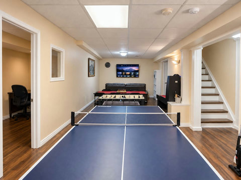 Basement games room with table tennis, air hockey, foosball and a board-game table adjoining the TV lounge.