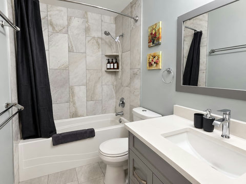 Shared upstairs bathroom with bathtub, shower, vanity and toilet.