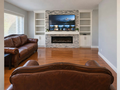 Main-floor family living room, viewed from the opening behind the loveseat toward the TV and fireplace.