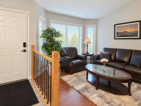 Front entry and main-floor front living room with seating and a coffee table.