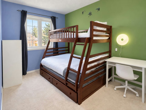 Bunk bedroom with a double lower bed, twin upper bed and desk.