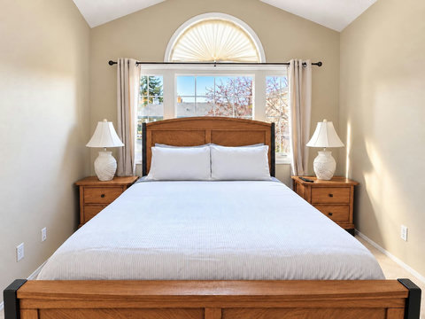 Queen bed in the primary bedroom, shown from the foot of the bed.