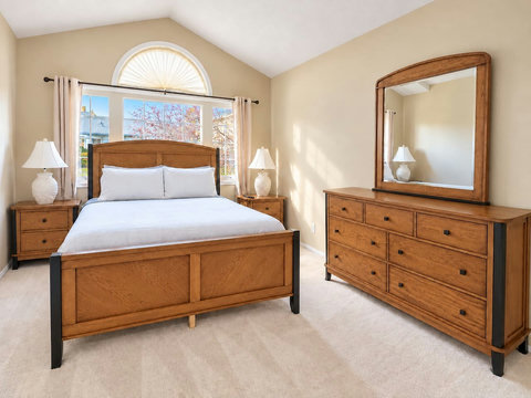 Primary bedroom upstairs with a queen bed, wood furnishings and a private ensuite bathroom.