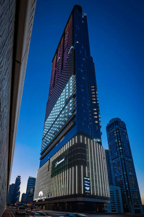 The Paramount Midtown Hotel and Residence modern skyscraper featuring vibrant LED-lit architecture in the heart of the city.