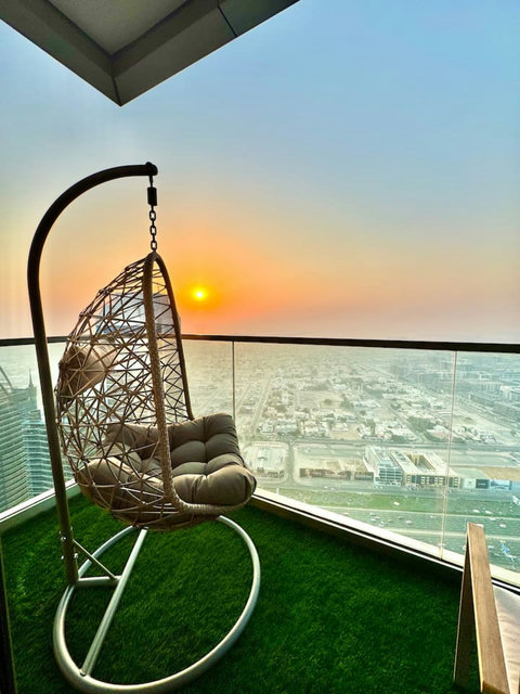 Enjoy a panoramic view of the bustling city, with towering skyscrapers and modern architecture, all set against an urban landscape from your balcony.