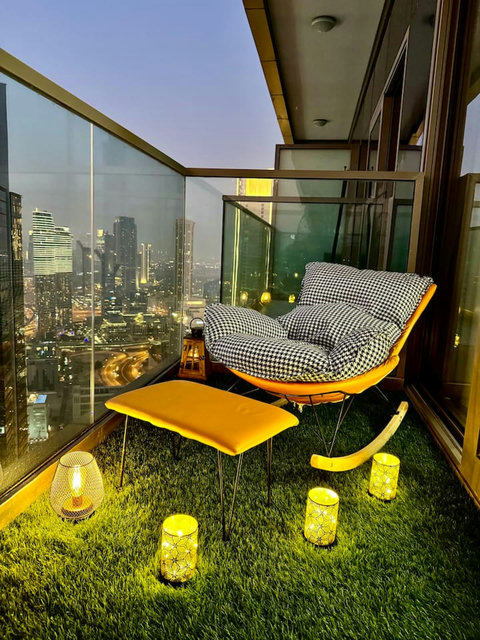 Enjoy a panoramic view of the bustling city, with towering skyscrapers and modern architecture, all set against an urban landscape from your balcony.