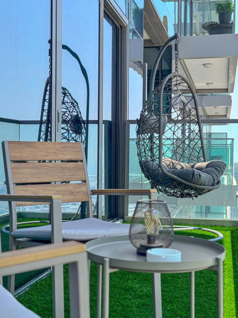 Enjoy a panoramic view of the bustling city, with towering skyscrapers and modern architecture, all set against an urban landscape from your balcony.