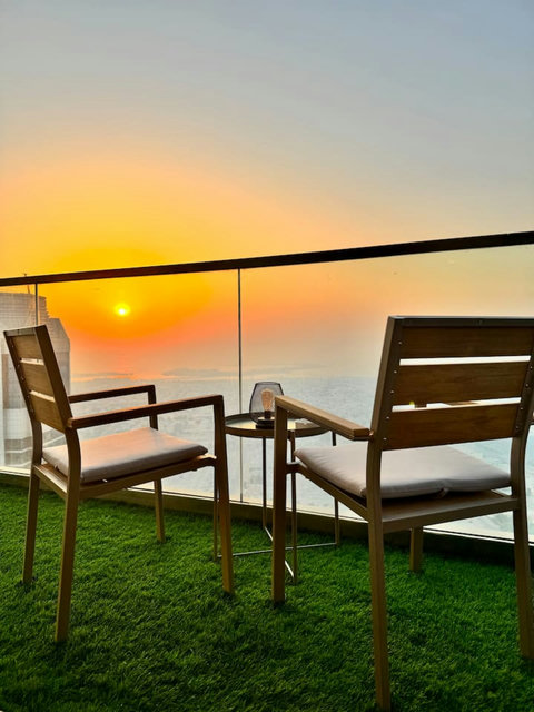 Enjoy a panoramic view of the bustling city, with towering skyscrapers and modern architecture, all set against an urban landscape from your balcony.