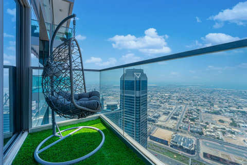 Enjoy a panoramic view of the bustling city, with towering skyscrapers and modern architecture, all set against an urban landscape from your balcony.