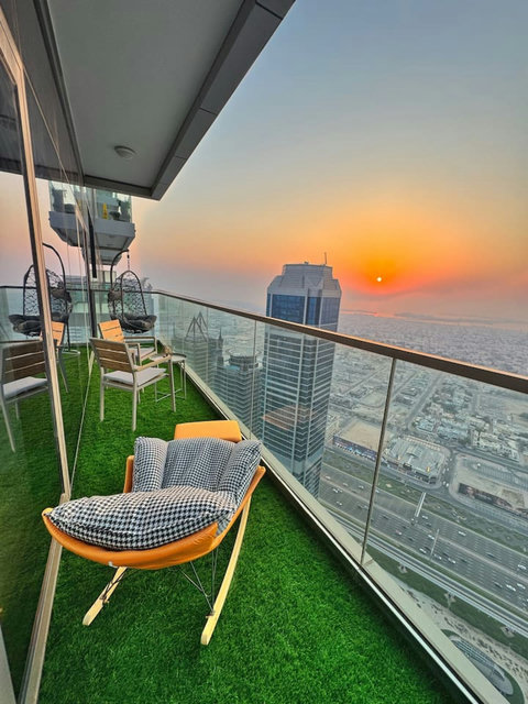 Enjoy a panoramic view of the bustling city, with towering skyscrapers and modern architecture, all set against an urban landscape from your balcony.