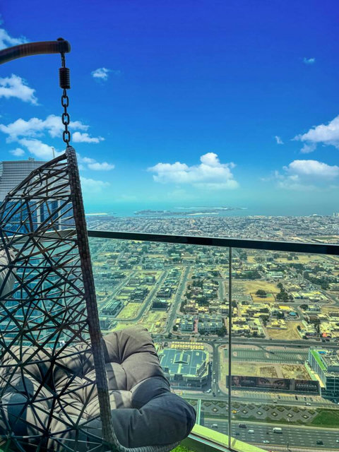Enjoy a panoramic view of the bustling city, with towering skyscrapers and modern architecture, all set against an urban landscape from your balcony.