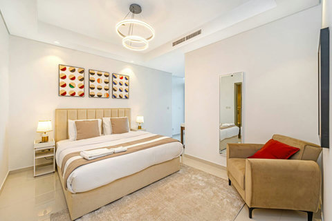 A cozy king bedroom with a stylish couch and plush bedding, all designed for your comfort. You’ll love the decorative pillows and luxurious finishes!vv