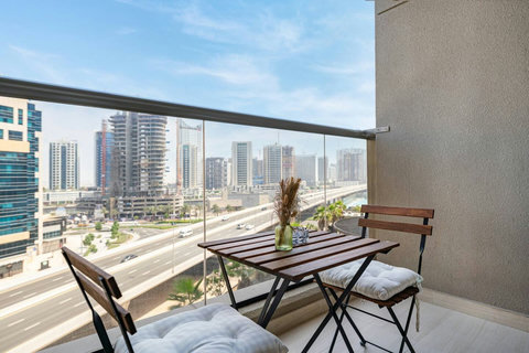 Enjoy a cozy balcony sitting area for two with uninterrupted views of Dubai's bustling city.