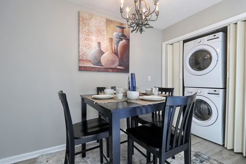 Dining Area: Enjoy meals under a charming chandelier with artful decor and convenient laundry.