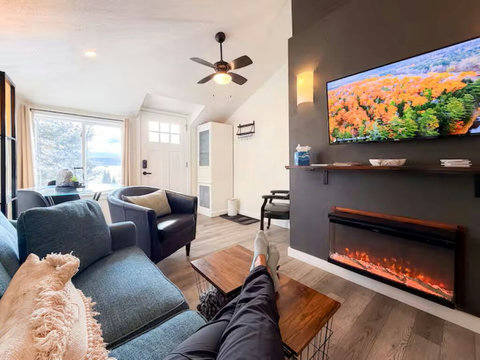 Cozy living room with fireplace, big-screen TV, and bright natural light