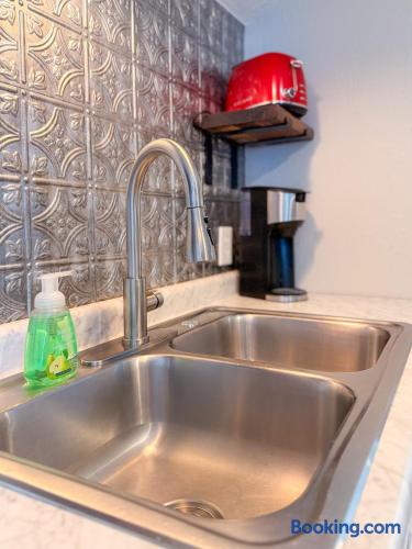 Stylish kitchen nook with double sink, coffee maker, and designer backsplash