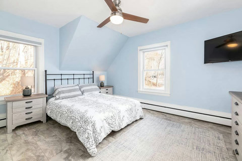 Upstairs Queen bed room with a bed that sits lower for guest who would prefer that. View to the woods out back and super quiet AC in the summer.