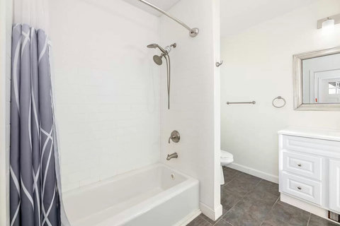 Full bathtub with handheld shower head.