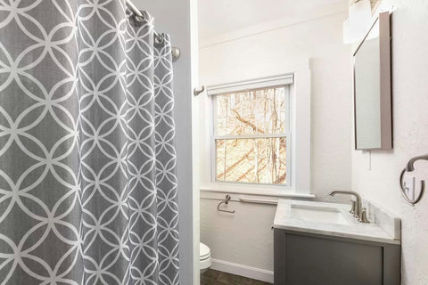 Full sized bathtub and shower with handheld shower head upstairs also has a full length mirror.