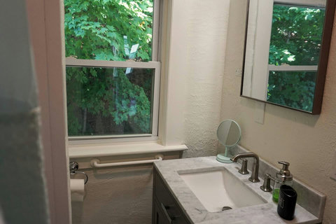Bathroom with a view of the trees on the hill out back reminds you that you aren't in the city but out on a getaway!