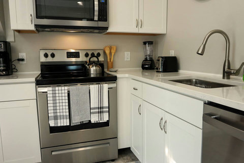 Full sized electric stove with oven. Full set of pots and pans and baking sheet. Drawer full of a variety of knives, utensils, and silverware for adults and kid-sized too!