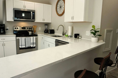 Lots of bright counter space and all the needed appliances and kitchenware.