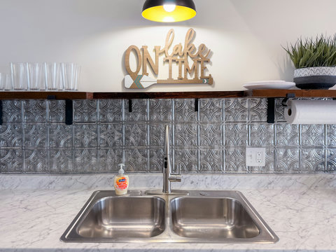 On lake time — the kitchen backsplash, barn light, and open shelving set the mood from the moment you walk in.