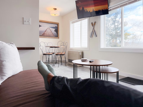 Bright cozy studio with bistro nook, big windows, and wall-mounted TV. Kick back, stream a show, and feel the Lakes Region pace wash over you — this is what a getaway should feel like.